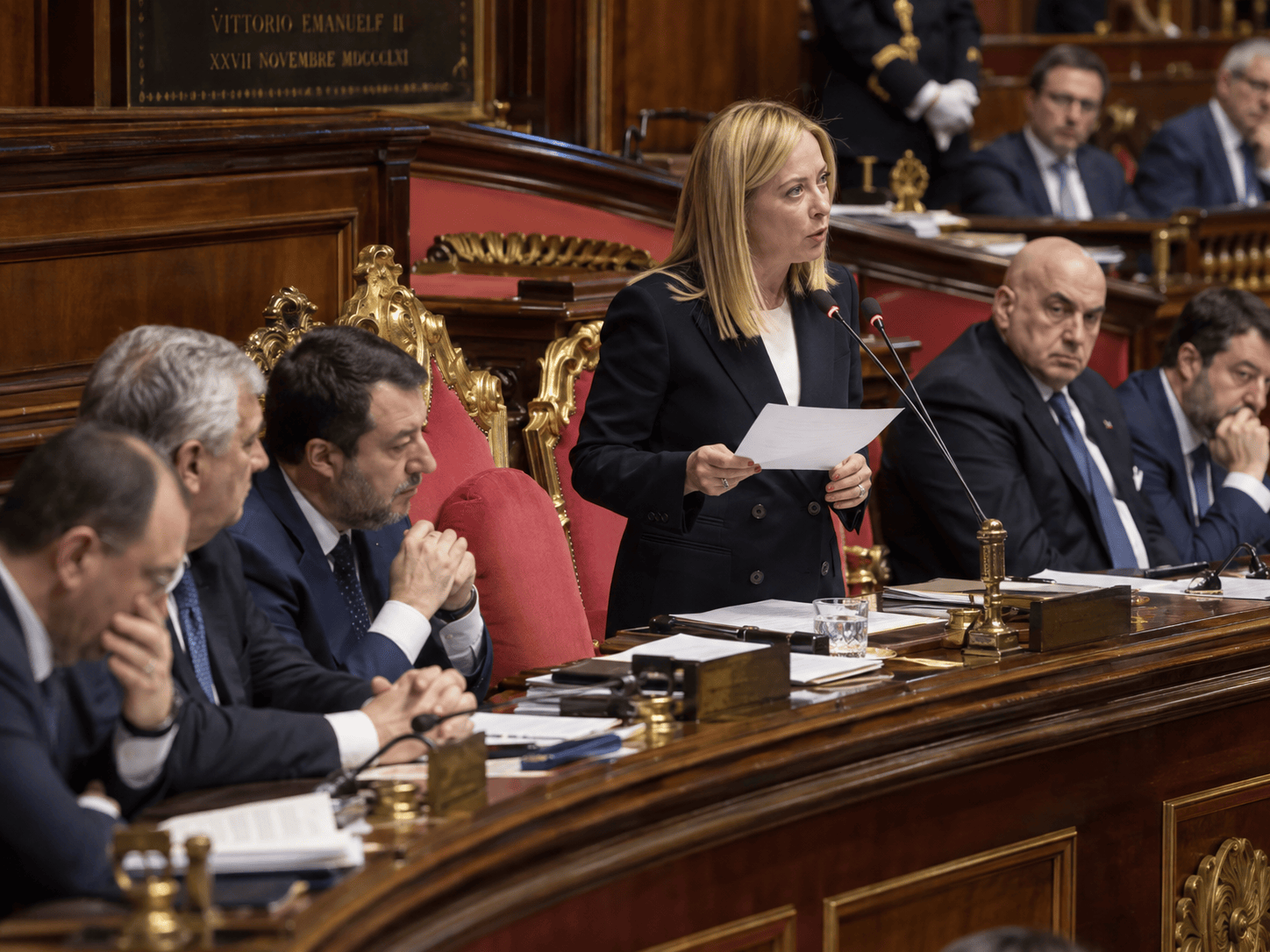 Donna al podio durante un intervento in un'aula parlamentare